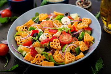 Pasta in the shape heart salad with tomatoes, cucumbers, olives, mozzarella and red onion Greek style.