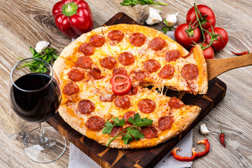 Photo of a hot pizza on wooden background. Toned image