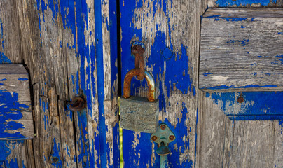 Rusty padlock on an old blue door
