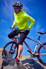 Obraz premium A cyclist who travels in the mountains in summer on a sunny day