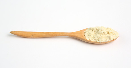 Full Powdered milk in wooden spoon over white background
