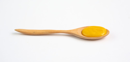 Vegetarian pumpkin soup in wooden spoon over white background