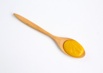 Vegetarian pumpkin soup in wooden spoon over white background