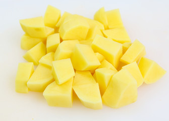 Sliced, peeled raw potatoes on a board
