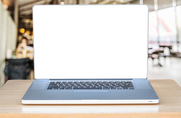 laptop computer with blank screen over wooden table indoor and blurred background