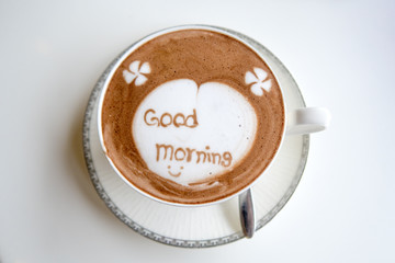 a cup of hot Chocolate with word “good morning” on white table background. top view.