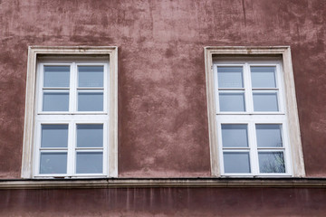 Two windows on the facade of the red old house