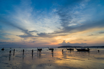 People on the Ao Nang beach at sunset in Krabi