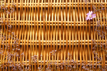 Small lilac flowers on the background of braided rods