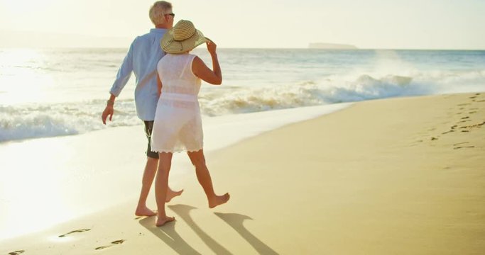 Happy Couple Walking on the Beach at Sunset