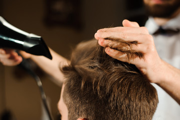 Master cuts hair and beard of men in the barbershop