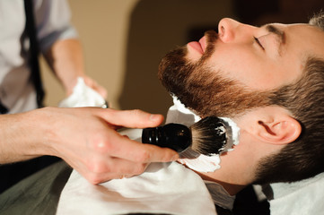 Master cuts hair and beard of men in the barbershop