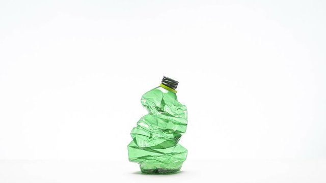 crushing plastic bottle on white background, stop motion