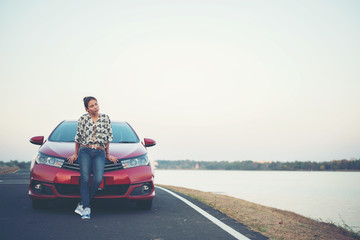 Fototapeta premium young woman sad and car at roadside and sunset time