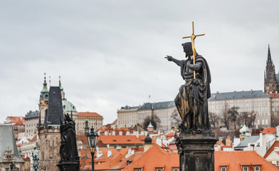Obraz premium Statue of St. John the Baptist with golden cross on Charles bridge in Prague