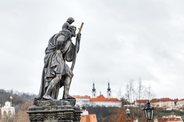 Fototapeta na wymiar Statue of Child Christus at the shoulder of saint Christopher, Patron of wanderers, navigators and travelers on Charles Bridge, Prague