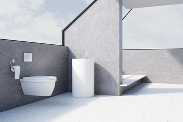 Gray bathroom with toilet, concrete, side