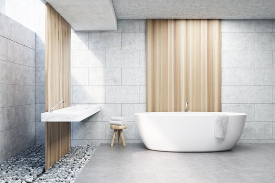 Gray brick bathroom, white tub, front