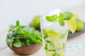 Fresh mojitos cocktail on wooden background. Mojitos with mint leaves, lime and ice. Drink making...