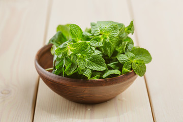 Green fresh mint om the wooden table, selective focus