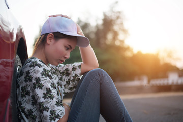 young woman sad and car at roadside and sunset time