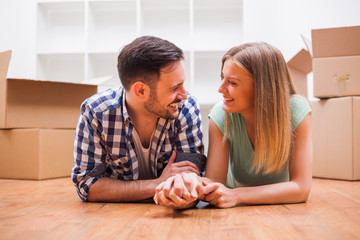 Young couple is moving in their new home. It's time for unpacking. 