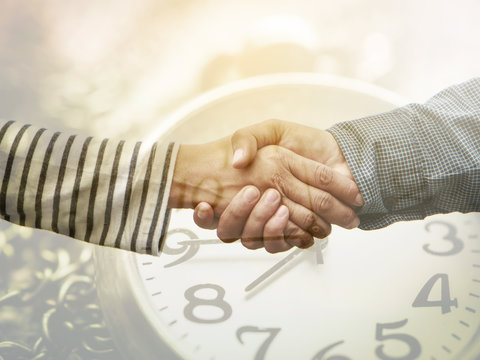 Double exposure clock and business man shaking hand for business real estate successful,business concept