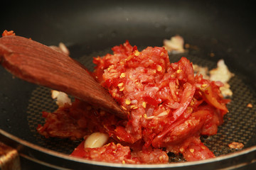 Cooking spicy meat with tomato dip by chef.