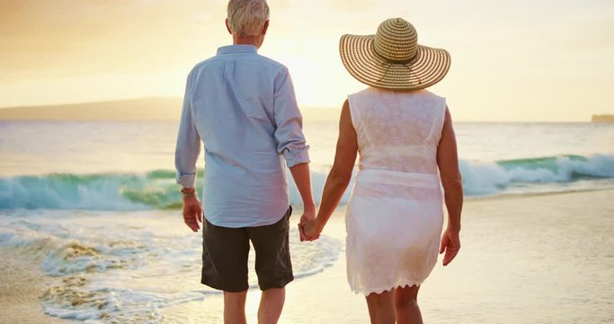 Happy Couple Walking on the Beach at Sunset