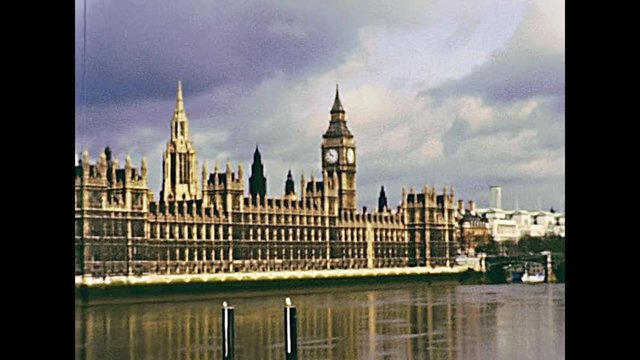Westminster Palace with Big Ben clock tower of London, Houses of Parliament by the river Thames. Historic restored footage on 1970s in England United Kingdom.