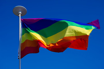 LGBT flag on blue sky background.