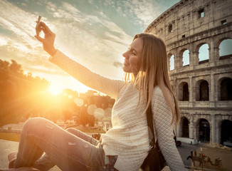 Woman tourist selfie with phone camera in hands near the Coliseu