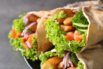 Plate with tasty kebab sandwiches on grey table