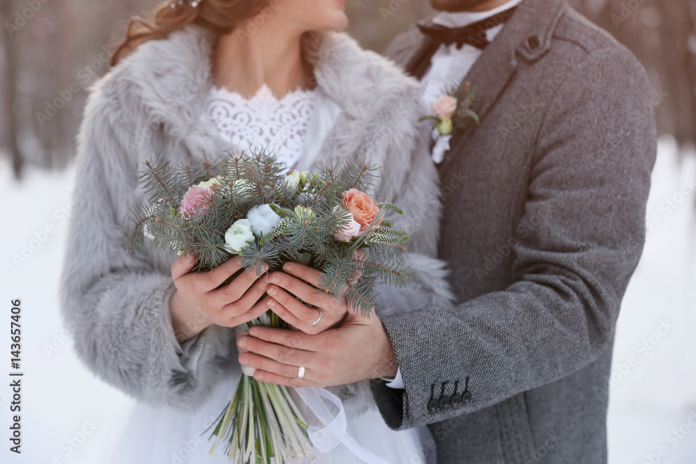 Wall mural happy wedding couple with bouquet outdoors on winter day, closeup