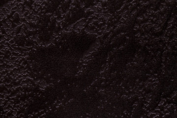 Dark brown background from a soft upholstery textile material, closeup.
