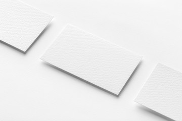 Mockup of three horizontal business cards at white textured background.