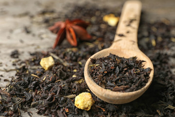 Wooden spoon and dried tea leaves, closeup