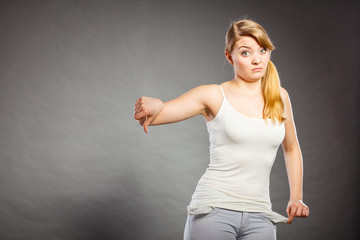 Upset sad woman showing empty pockets