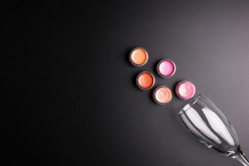 Lipstick cartridges and Wine glass isolated on black background, Cosmetics concept, Makeup concept, Copy space image for your text, Flat lay.