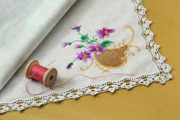 Thread with a needle and a handkerchief on a yellow background