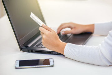Fototapeta premium Hands holding credit card and using laptop. Online shopping