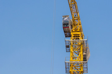 yellow construction tower crane with blue sky