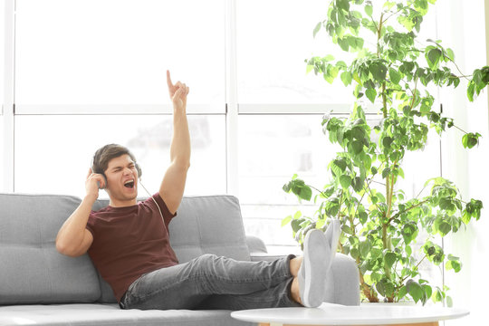 Handsome young man listening to music at home