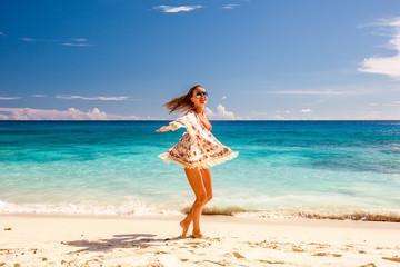 Woman with sarong on beach at Seychelles - obrazy, fototapety, plakaty