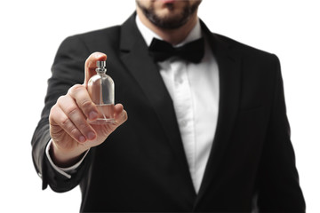 Handsome young man using perfume on white background