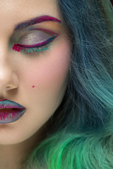 Space stunner. Vertical cropped closeup of a beautiful young woman with turquoise hair wearing artistic makeup posing with her eyes closed