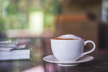 A white cup of coffee on wood table