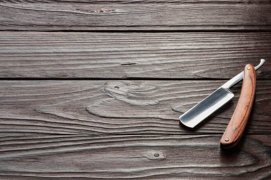 Vintage barber shop straight razor tool on wooden background