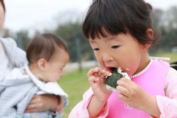 ピクニック　おにぎりを食べる女の子