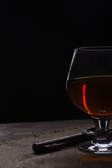 glass with cognac, whiskey and key on wooden table